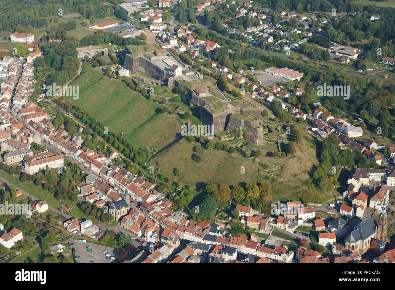 AERIAL VIEW. Medieval hilltop citadel overlooking the newest town. Bitche, Moselle, Lorraine, Grand Est, France. Stock Photo