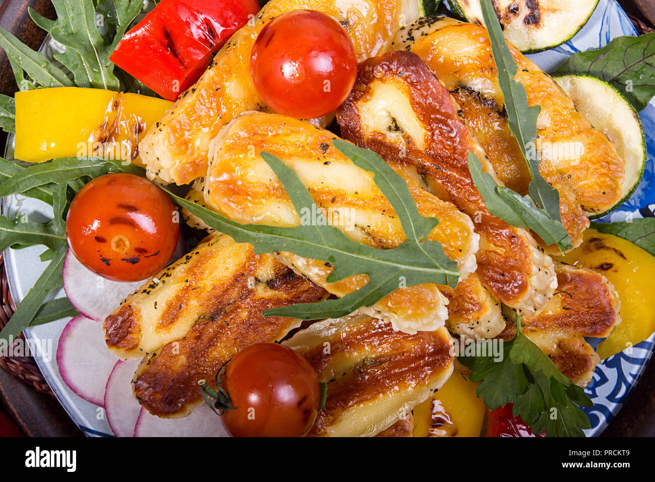 Grilled roasted halloumi cheese with grilled cherry tomato, pepper, zuccini. Tasty snack overhead. Stock Photo