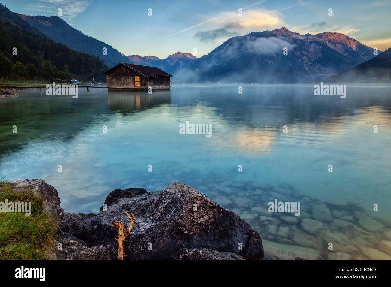 Rising fog at sunrise creates a great atmosphere at Lake Achensee in Austria. Stock Photo