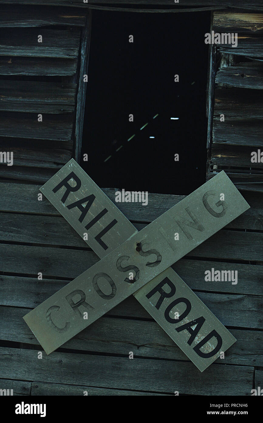 Railroad crossing sign used as decoration on old wooden barn Stock Photo