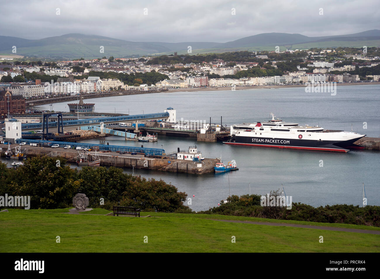 View from Douglas Head of Steam Packet catamaran at berth on Victoria pier and Ferry Terminal with Douglas Town in background on cloudy day. Stock Photo
