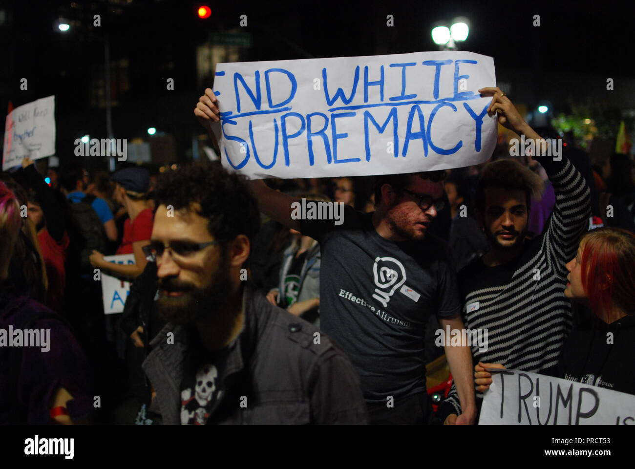 A protester carries a sign reading 'end white supremacy' during protests against the election of President Donald Trump in Oakland on Nov. 9, 2016. Stock Photo