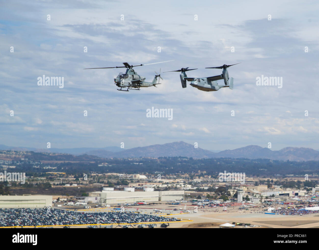 an AH-1Z Viper, left, alongside an MV-22B Osprey, right, fly high during the Marine Air Ground Task Force demonstration at the 2018 Marine Corps Air Station Miramar Air Show on MCAS Miramar, Calif., Sept. 30.This year's air show honors '100 years of women in the Marine Corps' featuring several performances and displays that highlights the accomplishments and milestones women have made since the first female enlistee, Opha May Johnson, Who joined the service in 1918. (U.S. Marine Corps photo by Lance Cpl. Raynaldo D. Ramos) Stock Photo