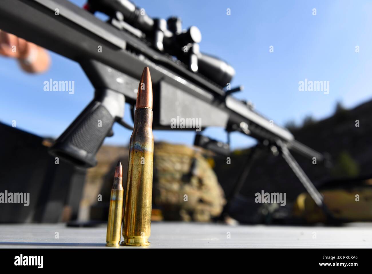 A .50-caliber bullet and a 7.62mm bullet rest in fron of a Barret M107 caliber rifle at Coulee Dam, Washington, Sept. 26, 2018. Airmen from the 92nd Civil Engineer Squadron explosive ordinance team underwent familiarization training with the Barret M107 caliber rifle as part of their annual weapons qualification. (U.S. Air Force photo/Airman 1st Class Lawrence Sena) Stock Photo
