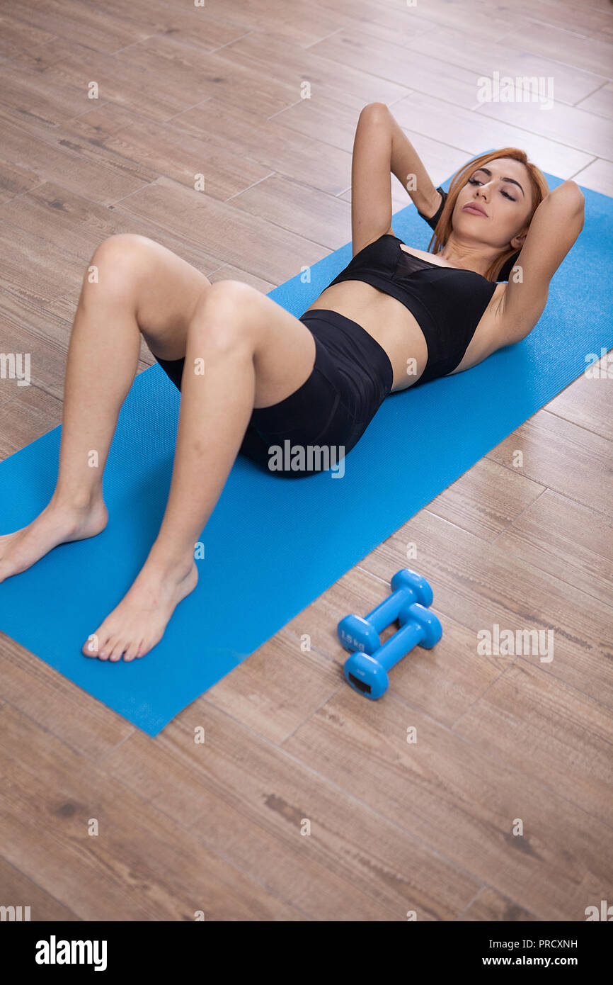 Girl doing abs crunches during her home training. No pain no gains Stock Photo Alamy