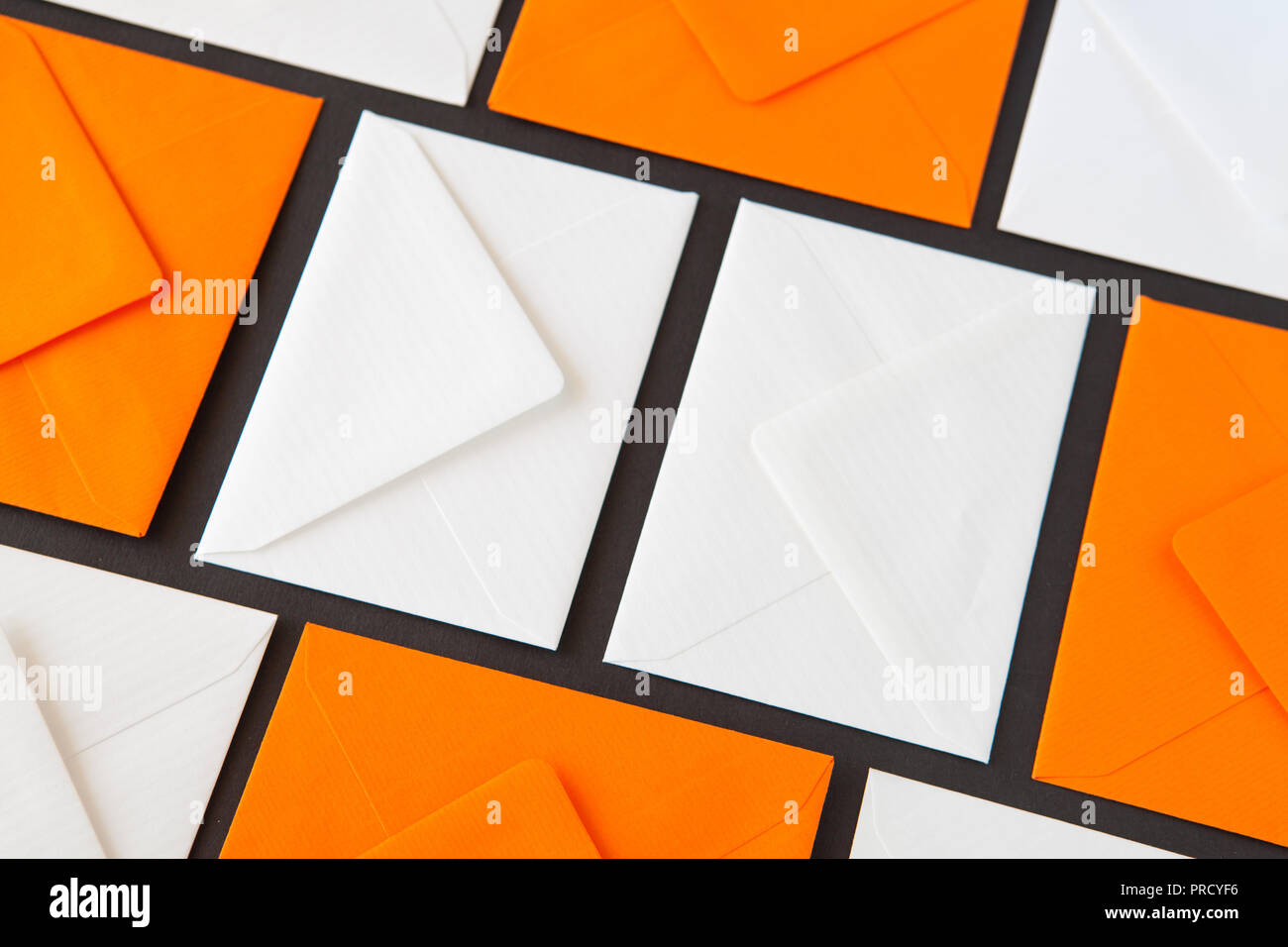Composition with white and orange envelopes on the table. Different colored envelopes on the table. Stock Photo
