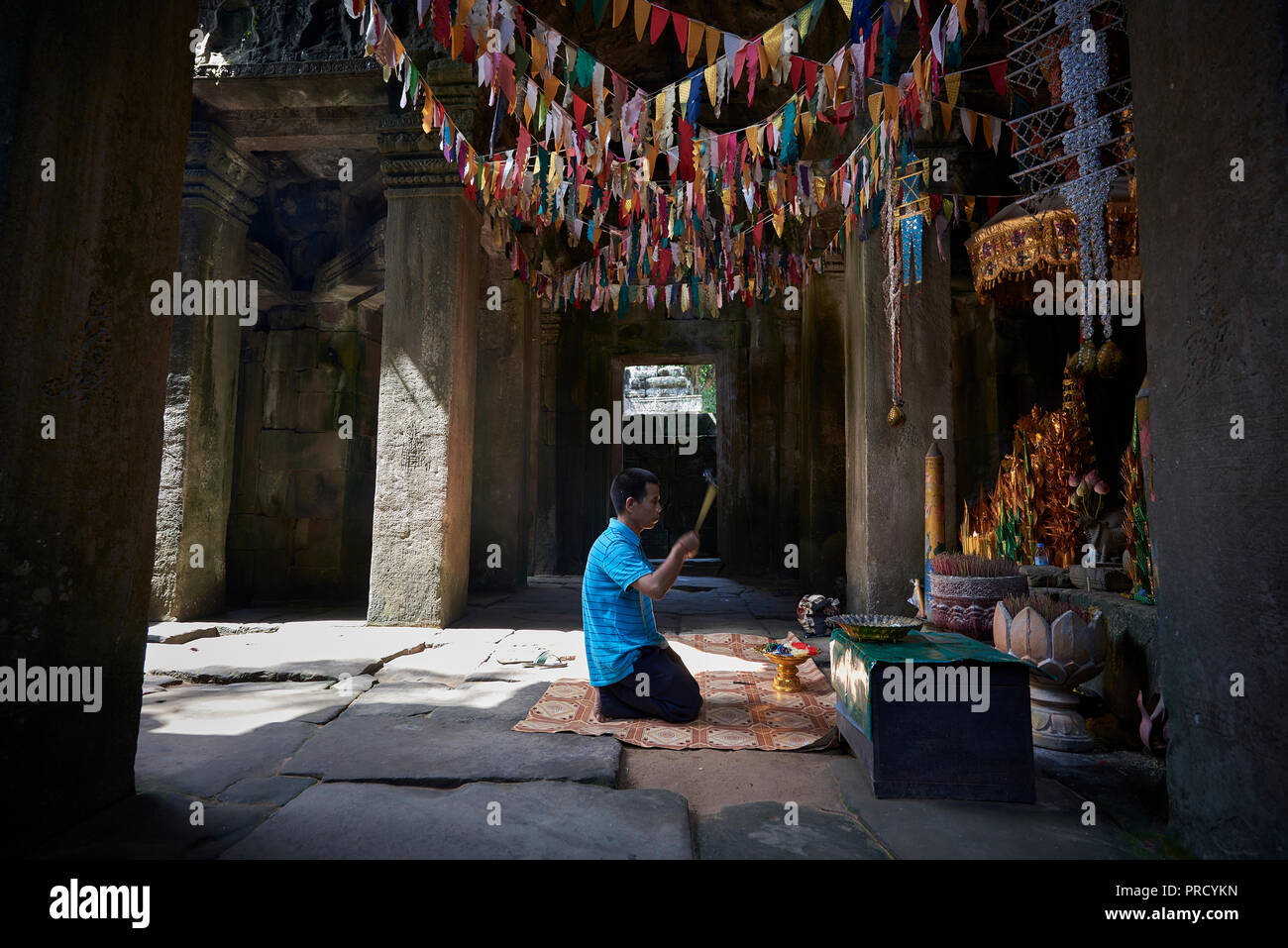 Man praying with incenses inside temple in Angkor Wat. The Angkor Wat complex, Built during the Khmer Empire age, located in Siem Reap, Cambodia, is t Stock Photo