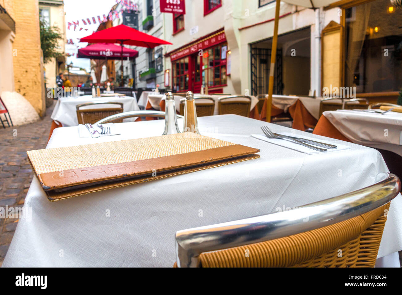 Outside tables laid out neatly with place settings at a restaurant in Church Lane, Windsor, UK. Stock Photo