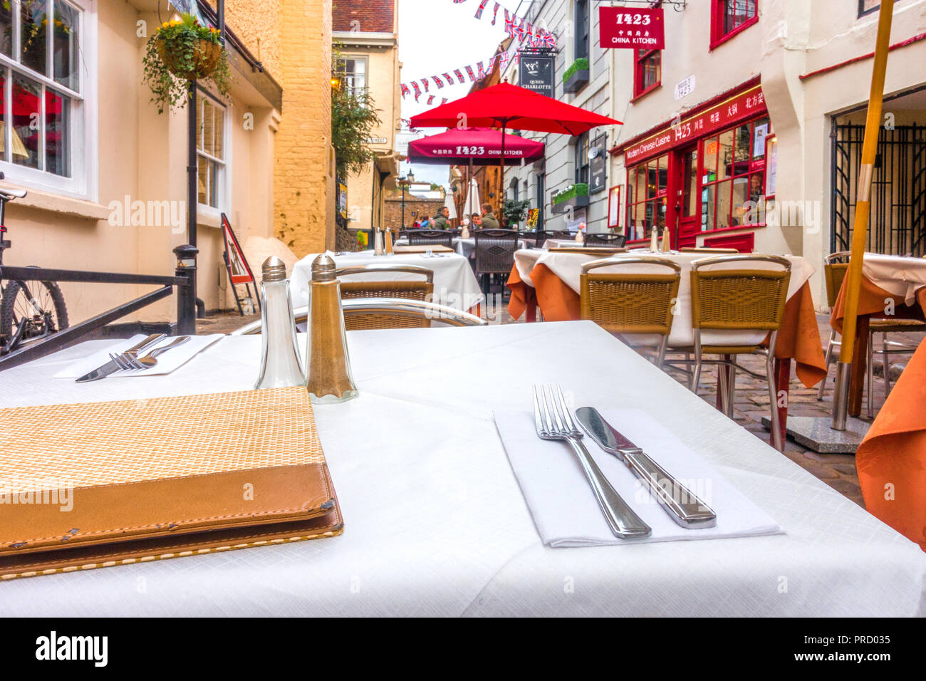 Outside tables laid out neatly with place settings at a restaurant in Church Lane, Windsor, UK. Stock Photo