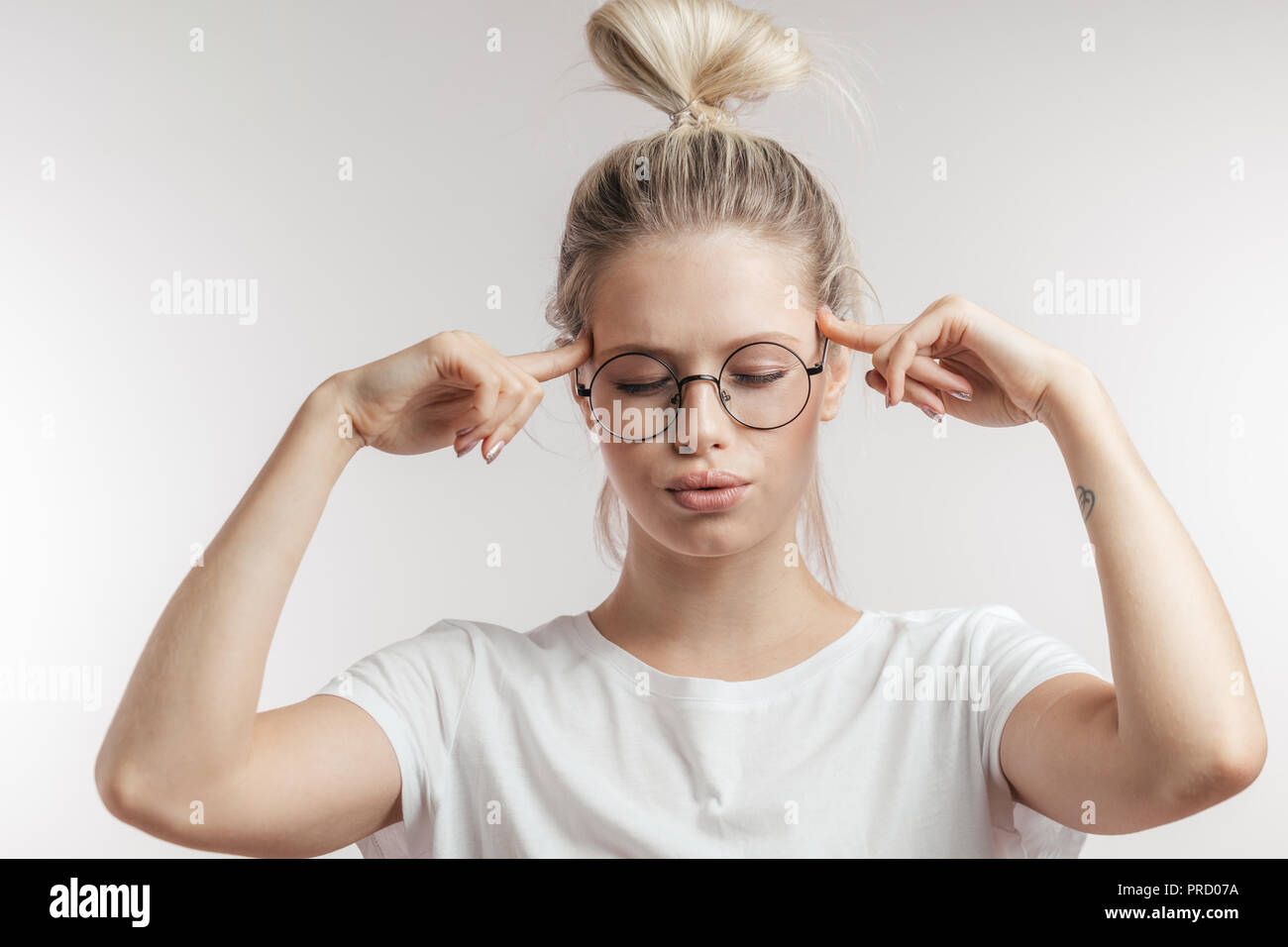Young woman fingers on temples hi-res stock photography and images - Alamy