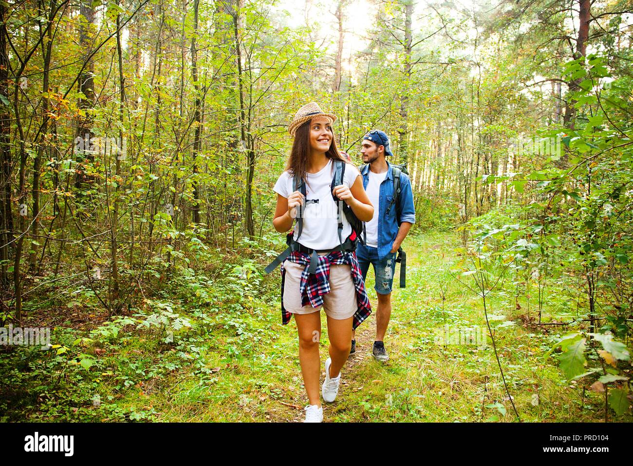 Tough route. Beautiful young couple hiking together in the woods while ...