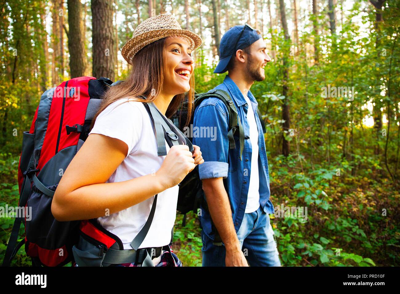 Tough route. Beautiful young couple hiking together in the woods while ...