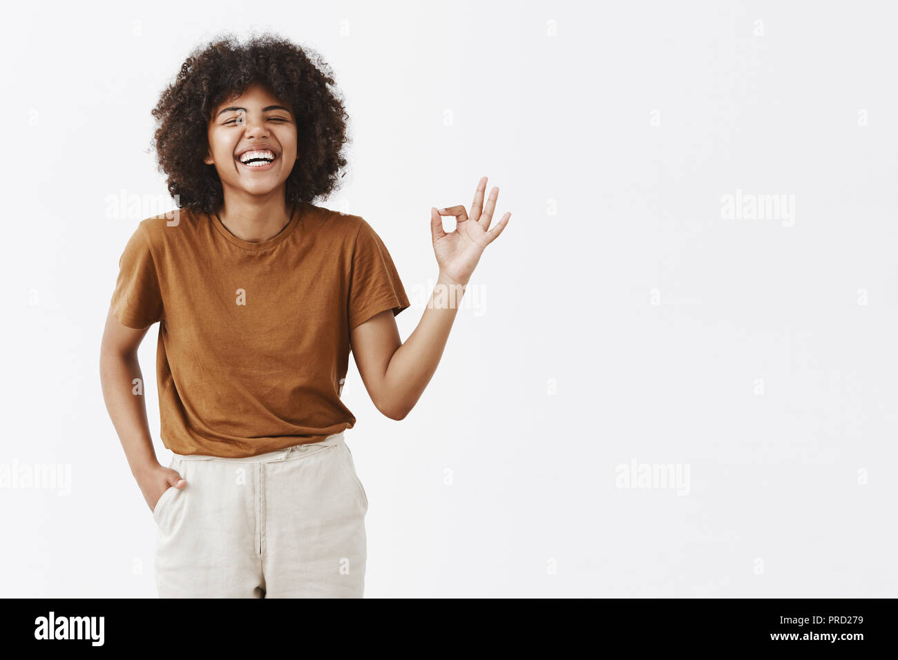 Girl showing her mood perfect. Carefree happy african american woman with curly hairstyle enjoying great company laughing out loud having fun showing ok or perfect sign with circled fingers Stock Photo - Girl showing her mood perfect. Carefree happy african american woman with curly hairstyle enjoying great company laughing out loud having fun showing ok or perfect sign with circled fingers Stock Photo -