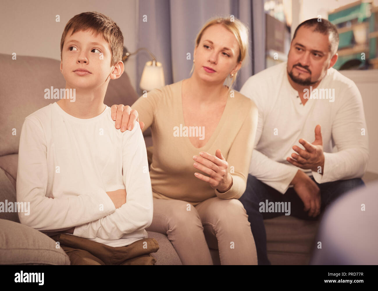 Portrait of upset boy scolded by parents at home Stock Photo - Alamy