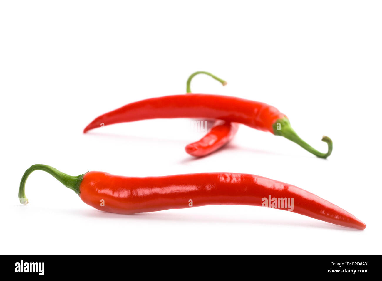 three red chili peppers on white background Stock Photo - Alamy