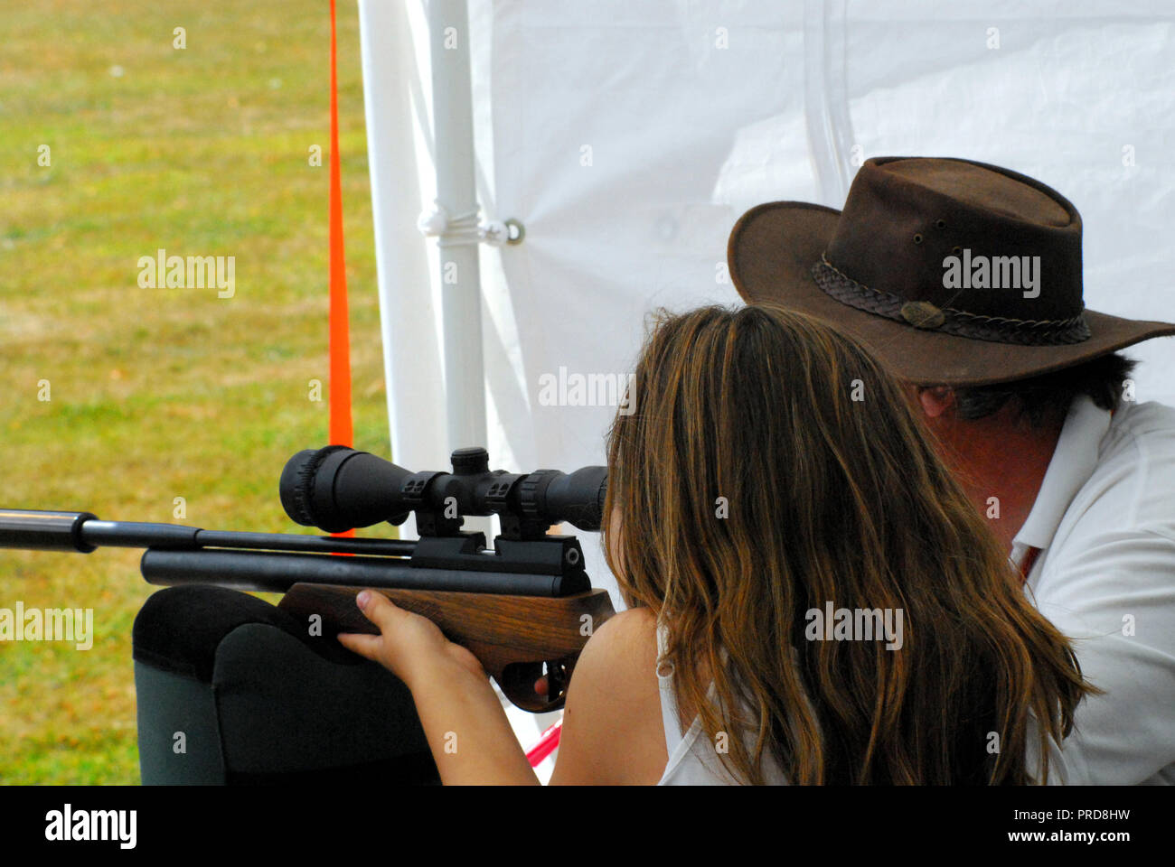 Close up of a young girl being taught to shoot a rifle. Please note- The people are not recognizable. Stock Photo