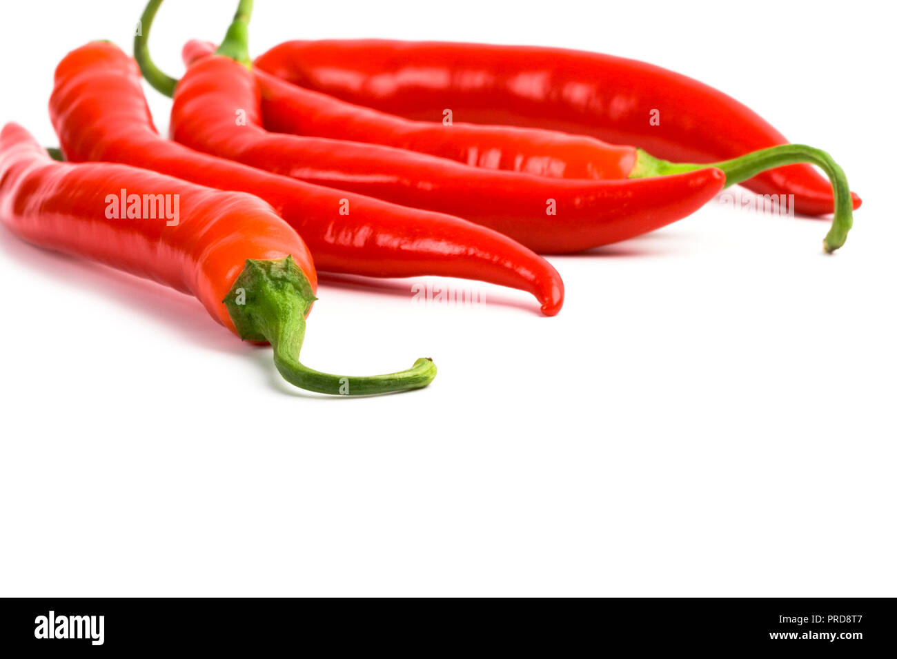 five red chilli peppers closeup on white background Stock Photo - Alamy