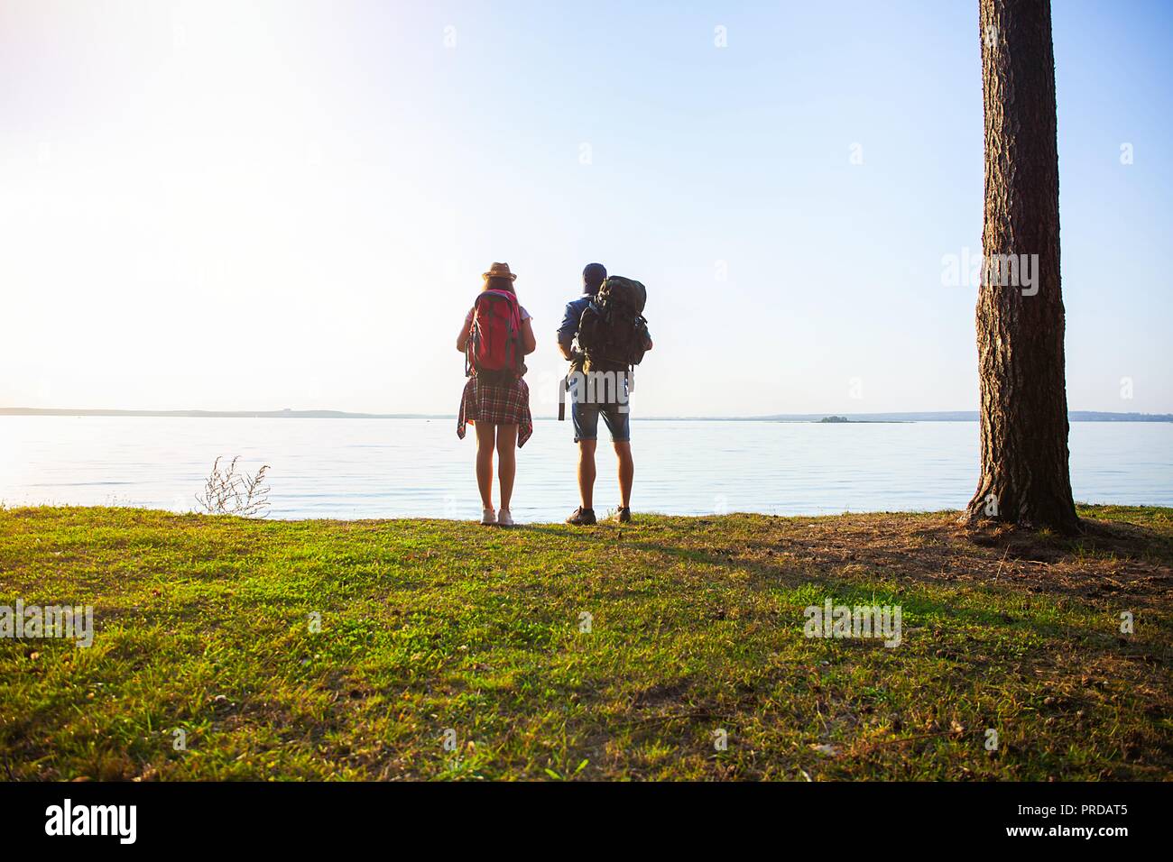 Tough route. Beautiful young couple hiking together in the woods while enjoying their journey. Stock Photo