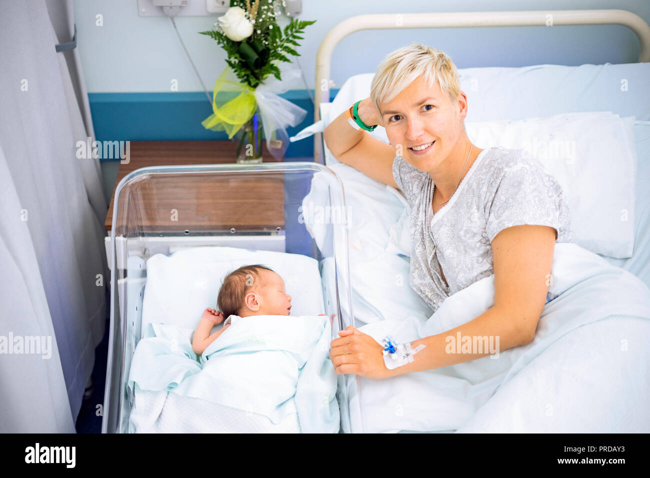 Happy mother enjoying her newborn baby boy still in the hospital, Poland Stock Photo