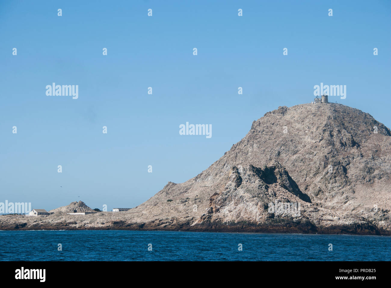 A view of the Southeast Farallon Island on a clear day. The crane and boat platform is on the left and the lighthouse is on top of the hill. Stock Photo