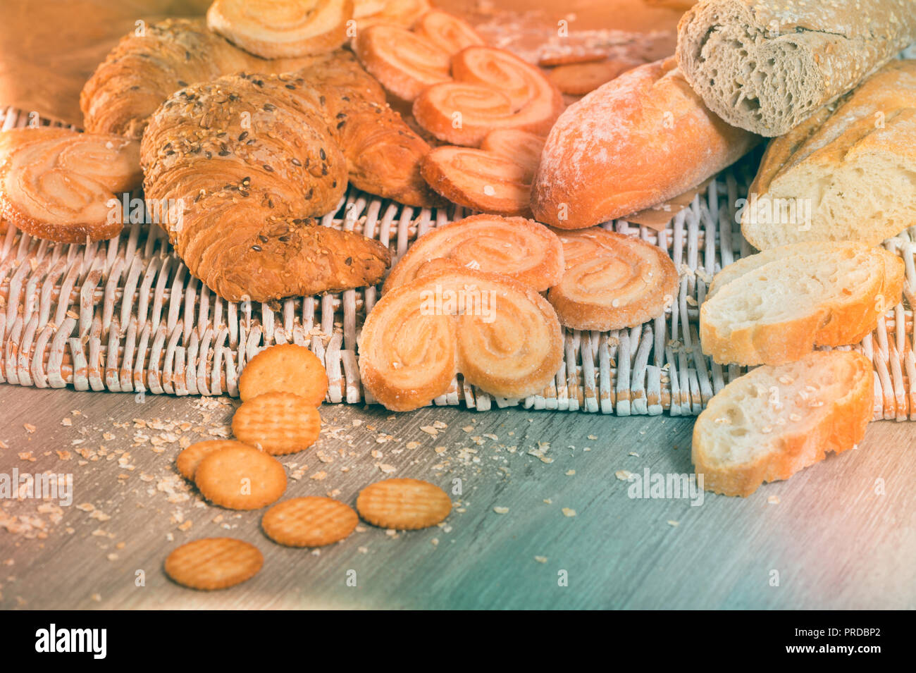 Various bakery and pastry products on rattan mat on wooden table Stock Photo