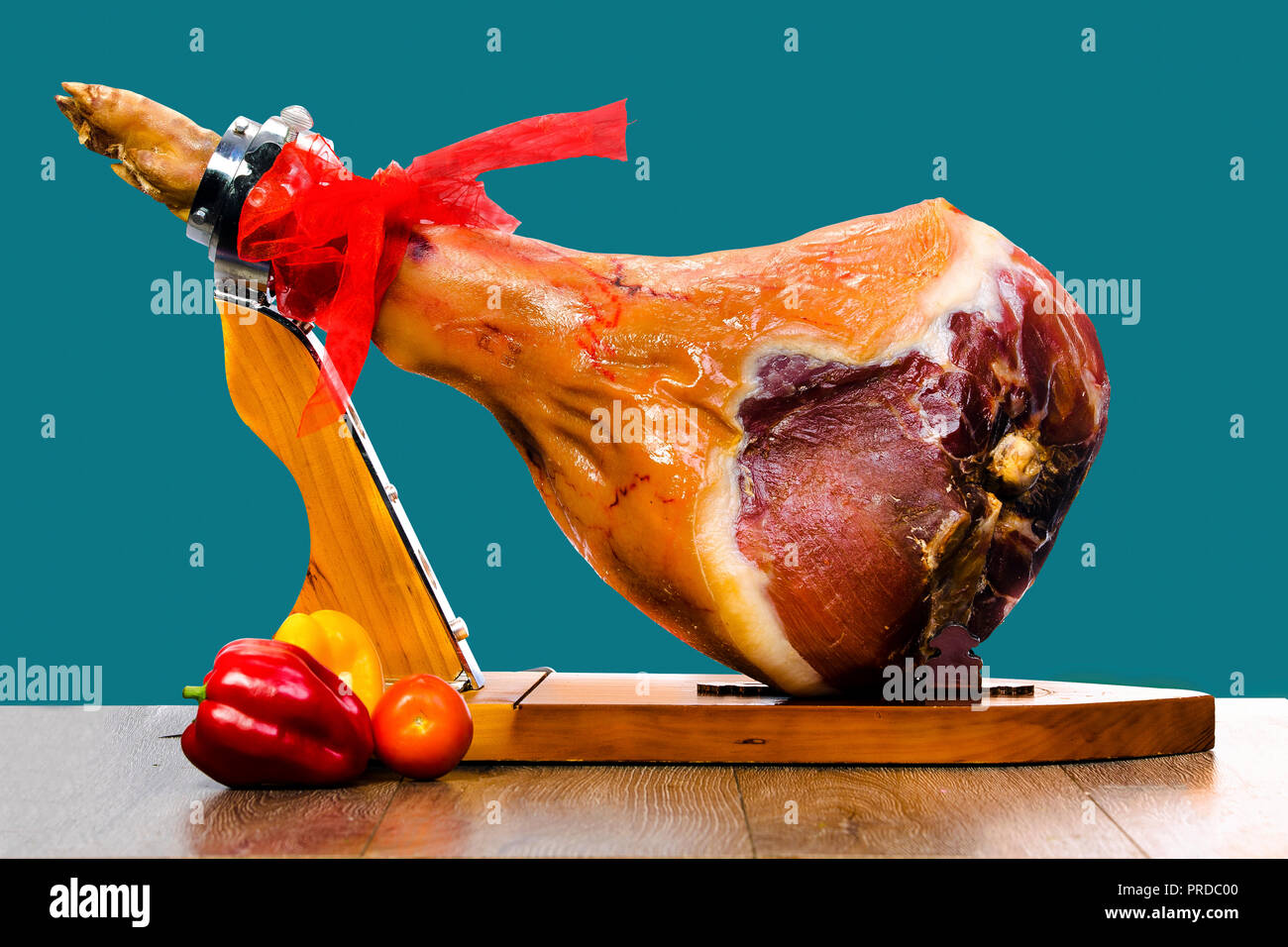 Parma ham (jamon) on a wooden stand isolated on blue background Stock Photo