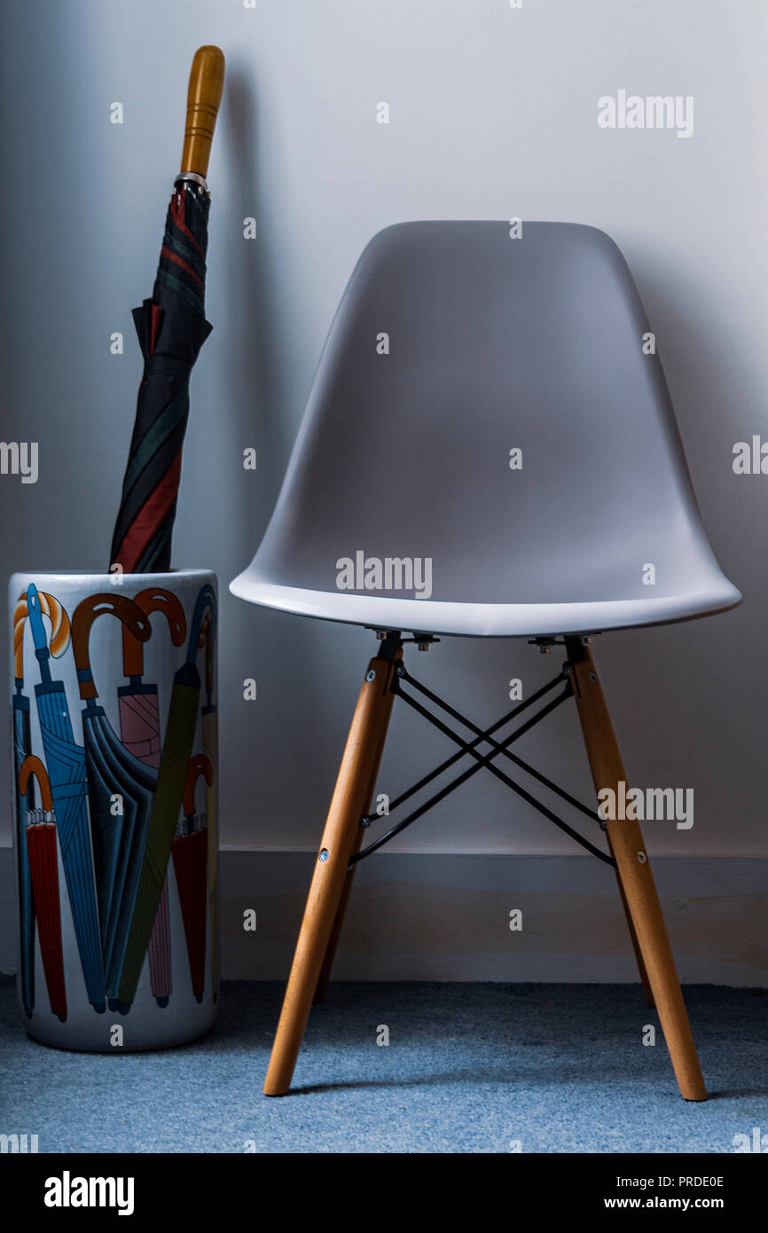 Eames style chair and an enamelled pottery umbrella stand Stock Photo