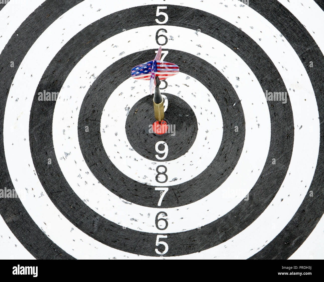 A dart with USA flag on the fletching in the center circle of a target Stock Photo