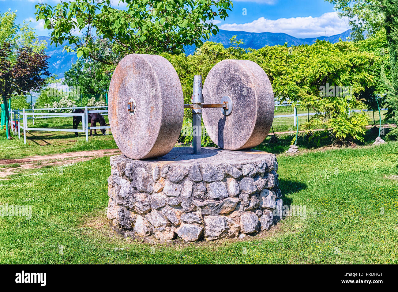 Ancient olive press with two millstones in the countryside Stock Photo
