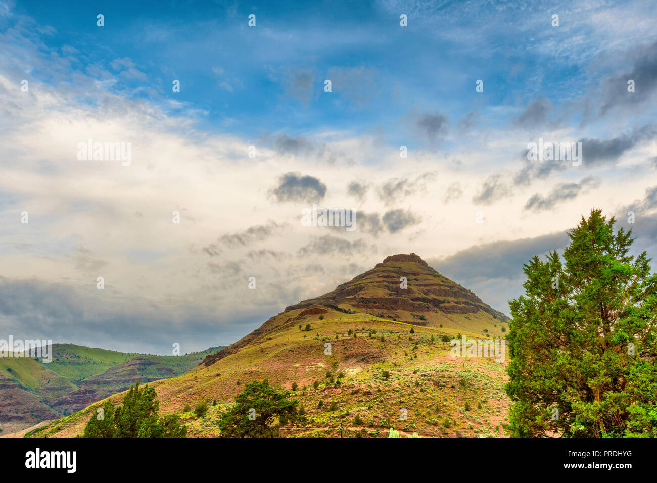 Geological landscape view under partly cloudy skies in the John Day Fossil Beds National Park Stock Photo