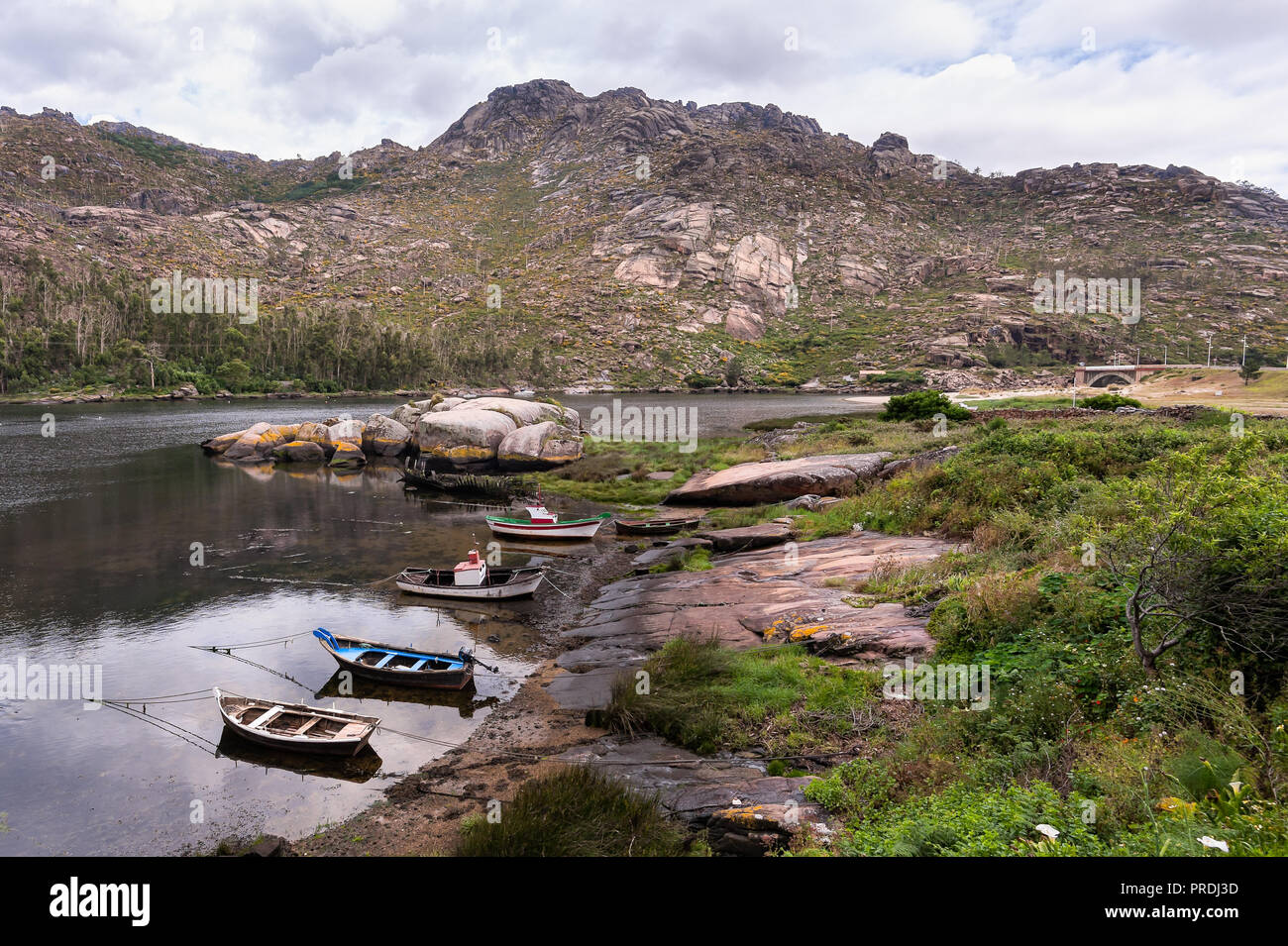 Landscape with fishing boats moored on shore. Galicia Spain Stock Photo