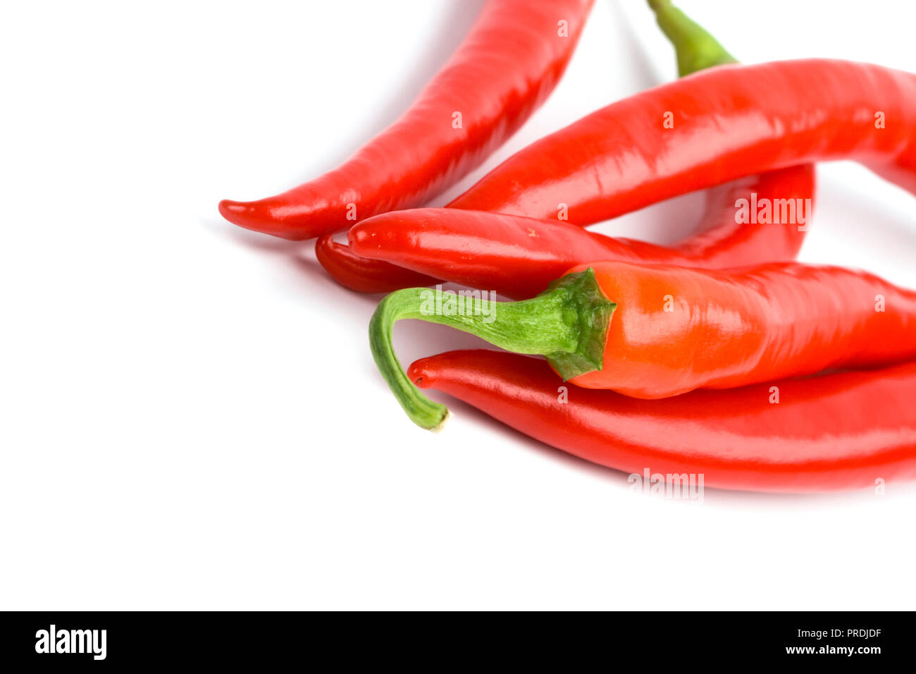 five red chilli peppers closeup on white background Stock Photo - Alamy