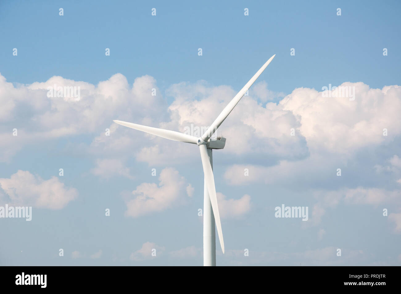 Wind turbine against blue sky and clouds background Stock Photo - Alamy