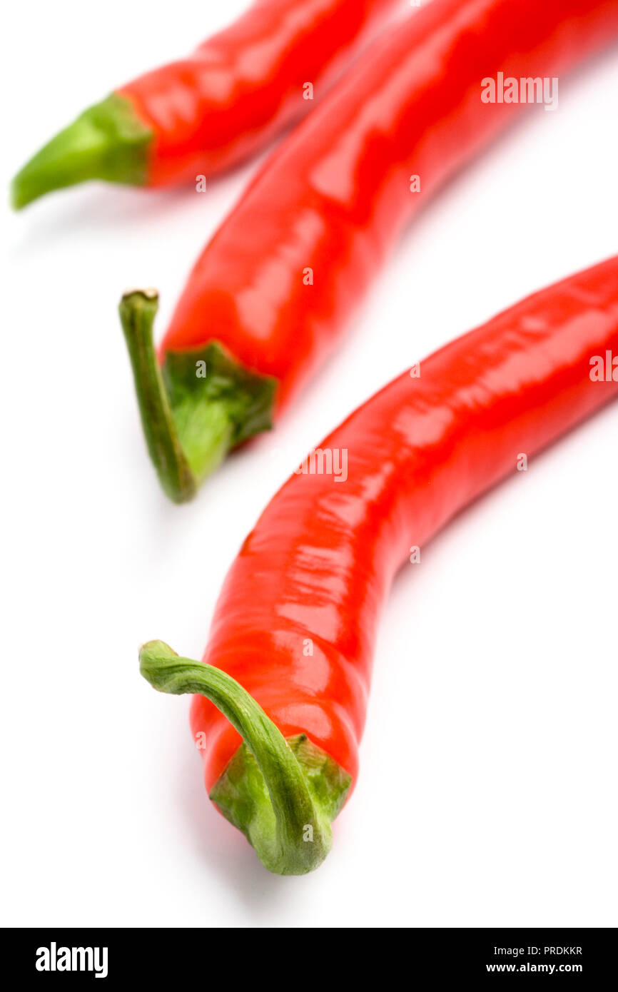 three red chili peppers closeup on white Stock Photo - Alamy