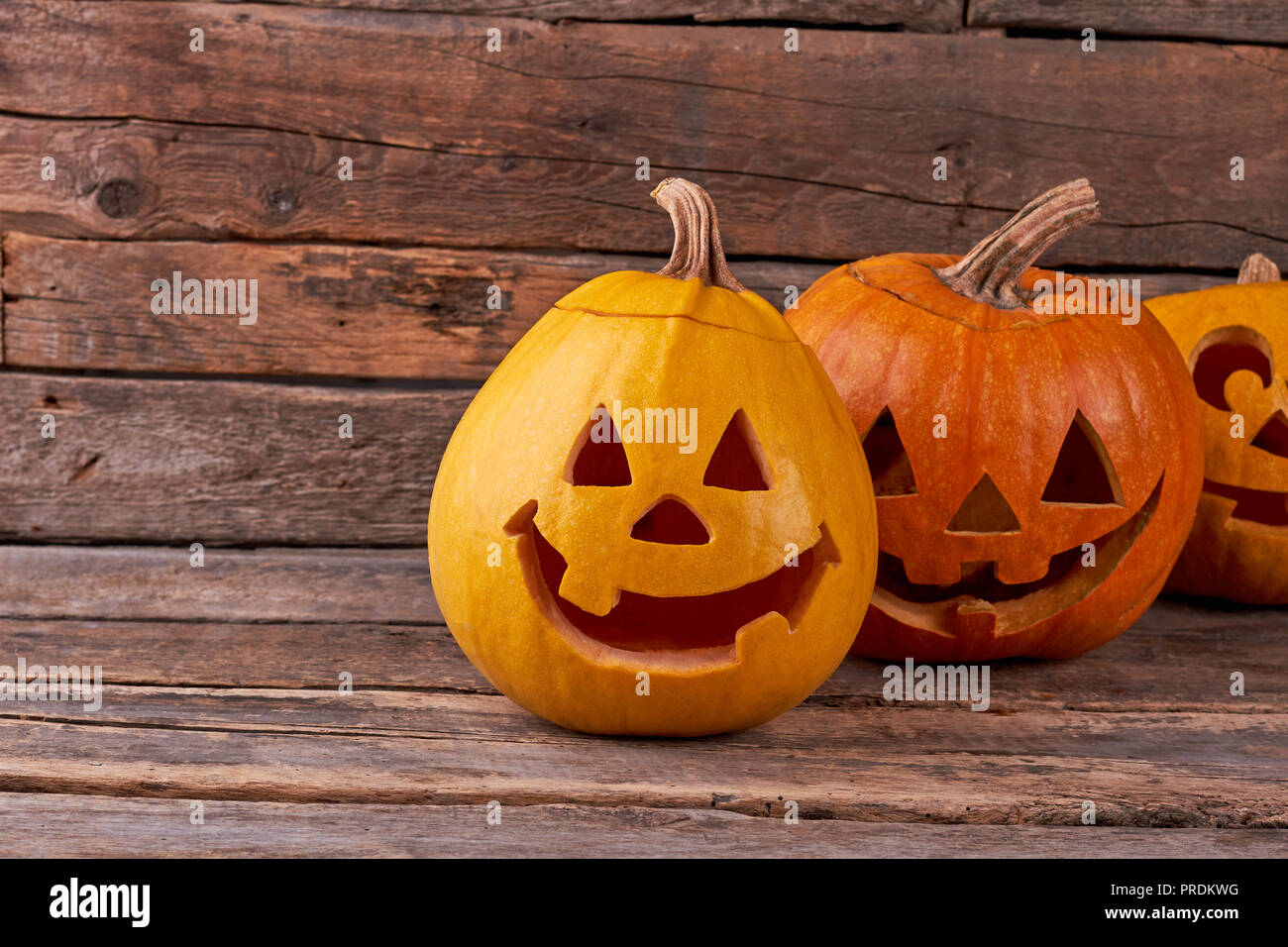 Funny Halloween pumpkins on rustic background. Stock Photo