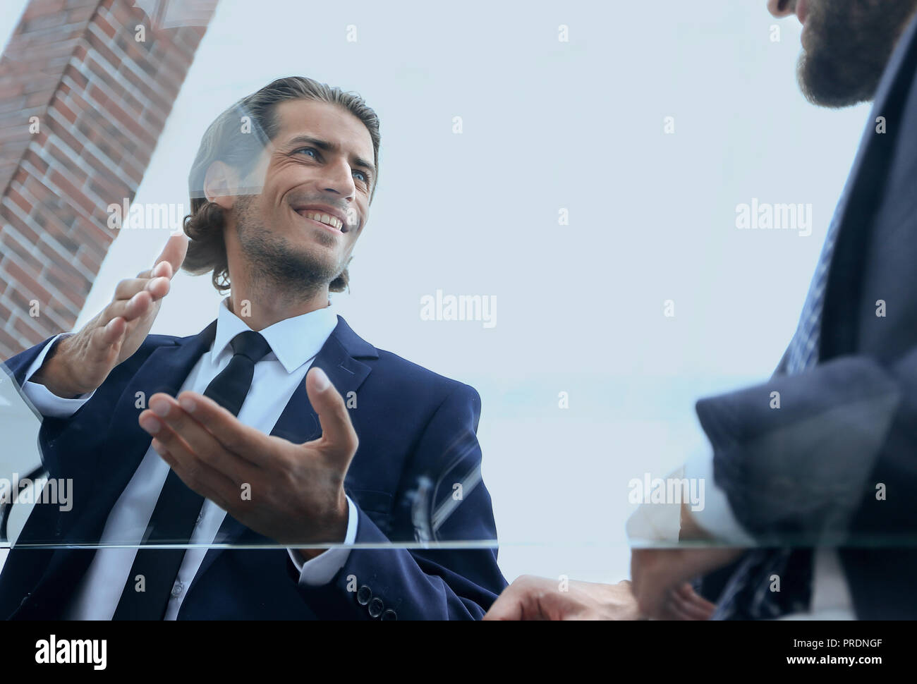 closeup.business partners talking, sitting behind a Desk Stock Photo