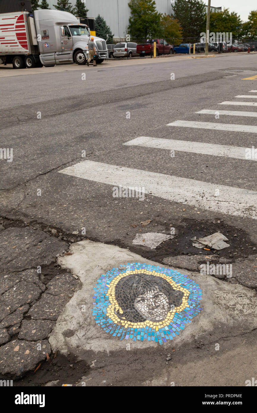 Detroit, Michigan - A pothole patched with an artistic mosaic of Aretha Franklin on a street in the Eastern Market district. Chicago artist Jim Bachor Stock Photo