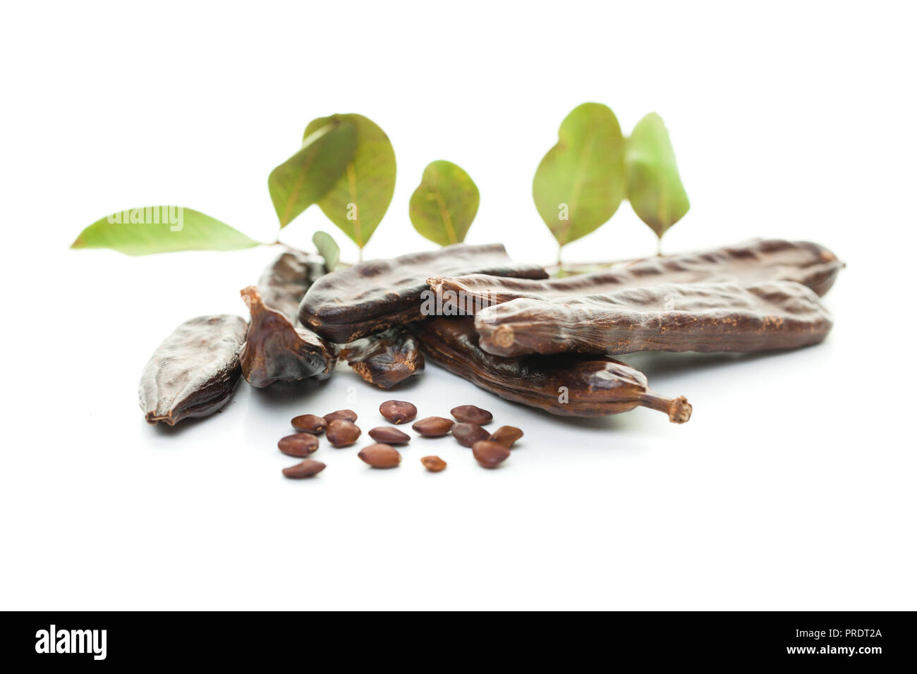 Carob bean on white. Healthy organic sweet carob pods with seeds and