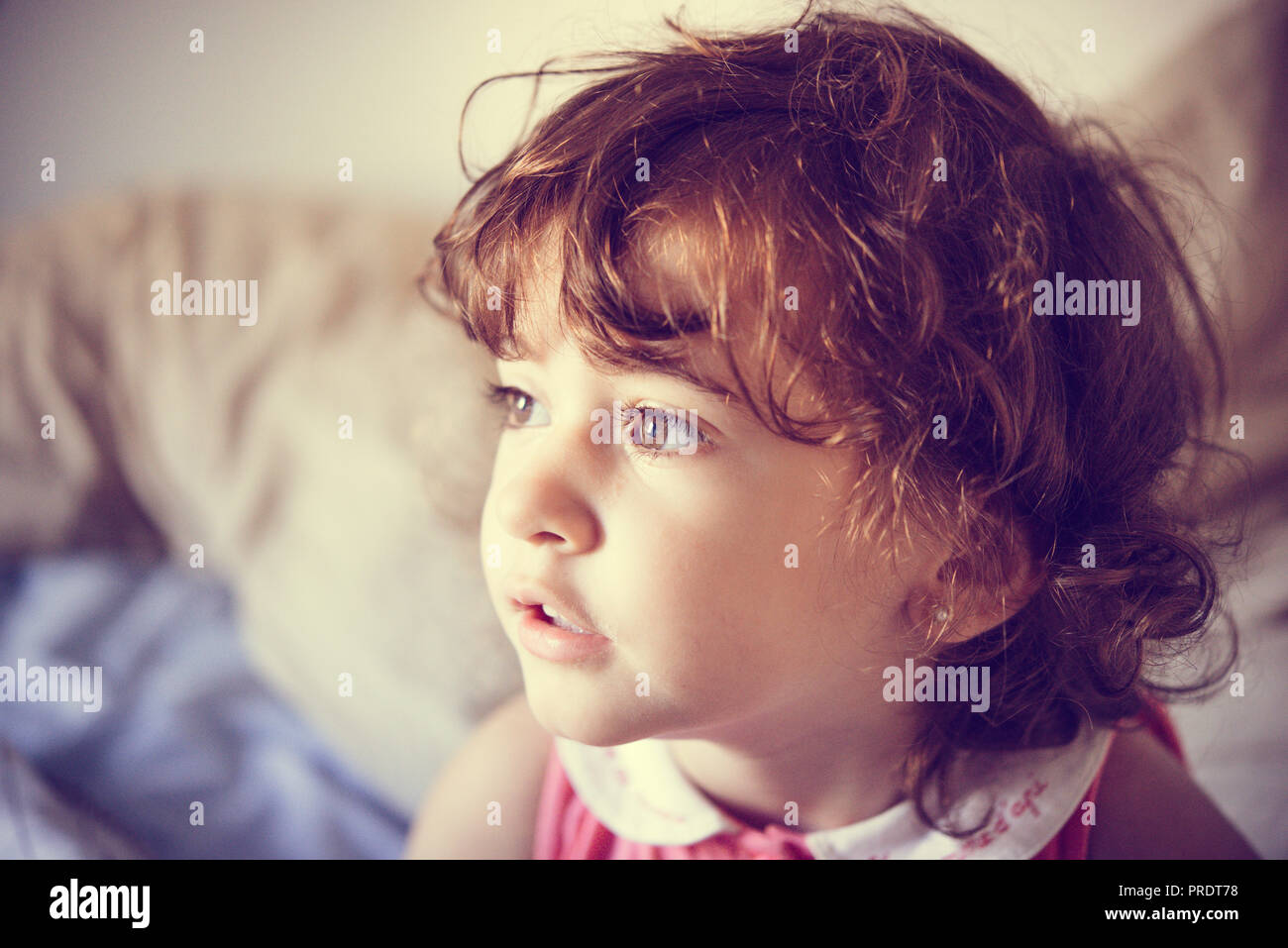 Adorable little girl with curly hair tousled at home Stock Photo