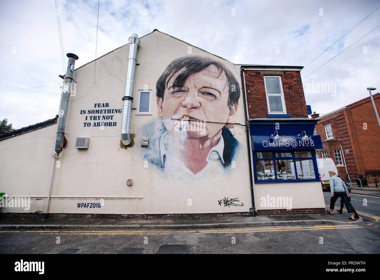 Prestwich, UK. 1st Oct 2018. Graffiti artist Akse p19 completes his portrait of 'The Fall' frontman Mark E.Smith on the side of a Manchester chip shop. 'The Fall' singer, who died in January 2018, is being commemorated in his hometown of Prestwich, Greater Manchester for an Arts Festival. Credit: Howard Harrison/Alamy Live News Stock Photo