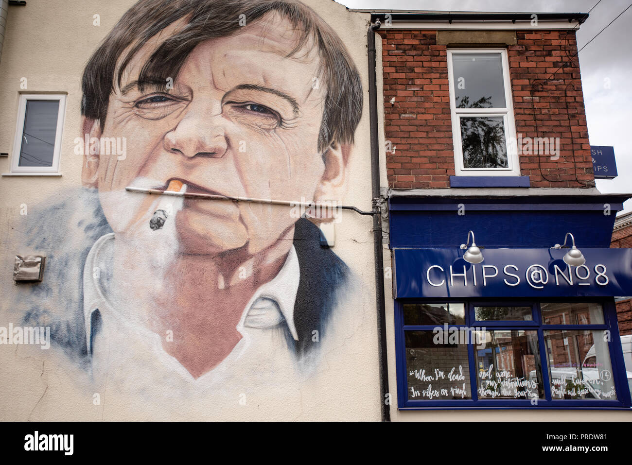 Prestwich, UK. 1st Oct 2018. Graffiti artist Akse p19 completes his portrait of 'The Fall' frontman Mark E.Smith on the side of a Manchester chip shop. 'The Fall' singer, who died in January 2018, is being commemorated in his hometown of Prestwich, Greater Manchester for an Arts Festival. Credit: Howard Harrison/Alamy Live News Stock Photo