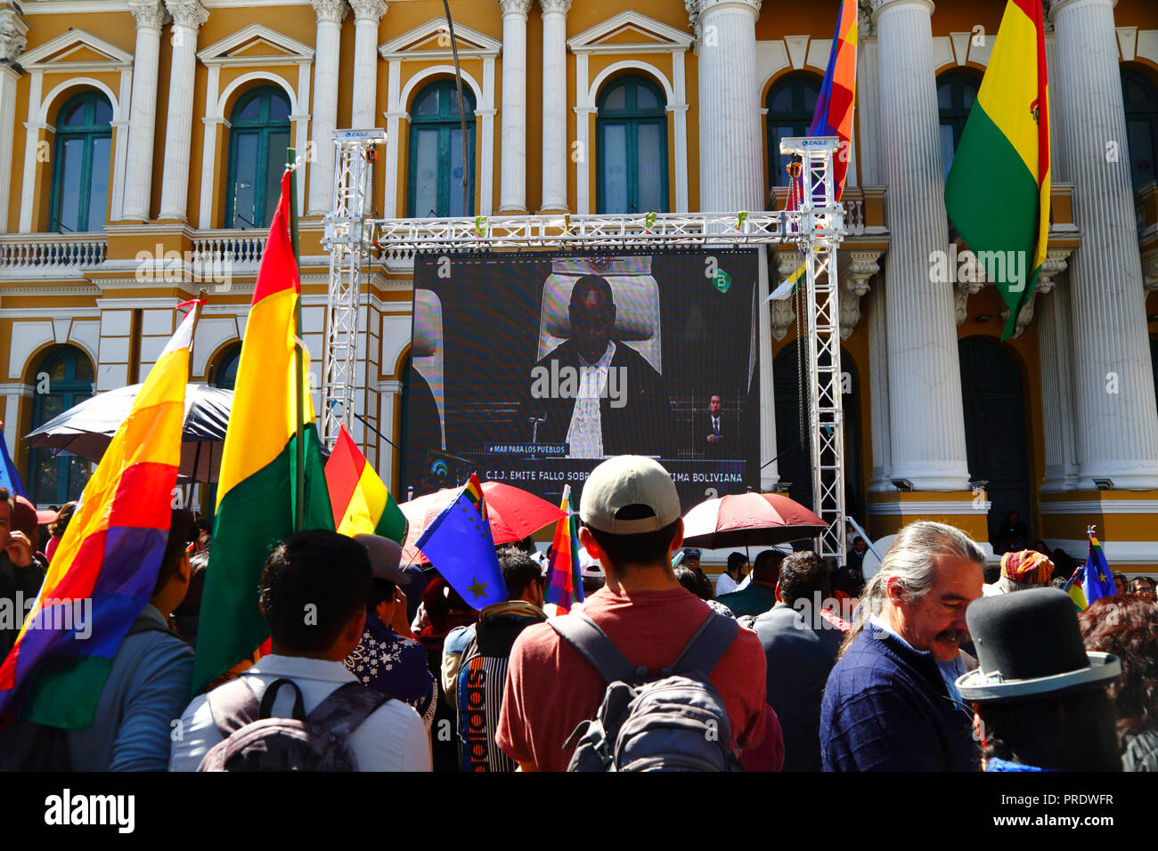 La Paz, Bolivia, 1st October 2018. People watch the ruling for the case "Obligation to Negotiate Access to the Pacific Ocean (Bolivia v. Chile)" at the International Court of Justice in The Hague on a giant screen in front of the Congress building in Plaza Murillo. Bolivia presented the case to the ICJ in 2013; Bolivia lost its coastal Litoral province to Chile during the War of the Pacific (1879-1884) and previous negotiations have made no progress from Bolivia's viewpoint. Credit: James Brunker/Alamy Live News Stock Photo