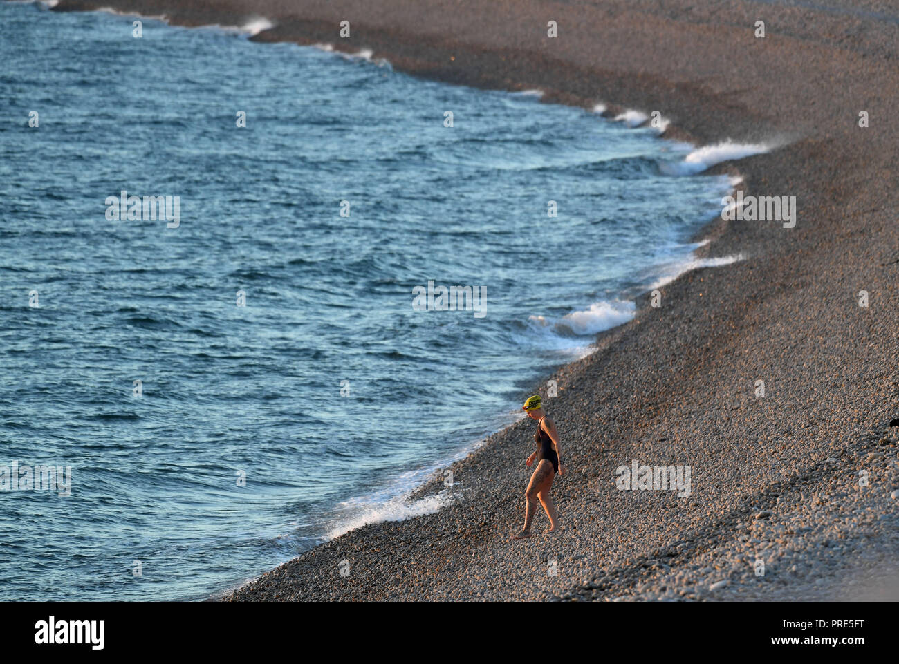 Portland, Dorset, UK. 1st Oct, 2018. Sun sets on Chesil Beach at Portland in Dorset. A swimmer takes to the water at sunset on Chesil beach, Portland, Dorset Credit: Finnbarr Webster/Alamy Live News Stock Photo