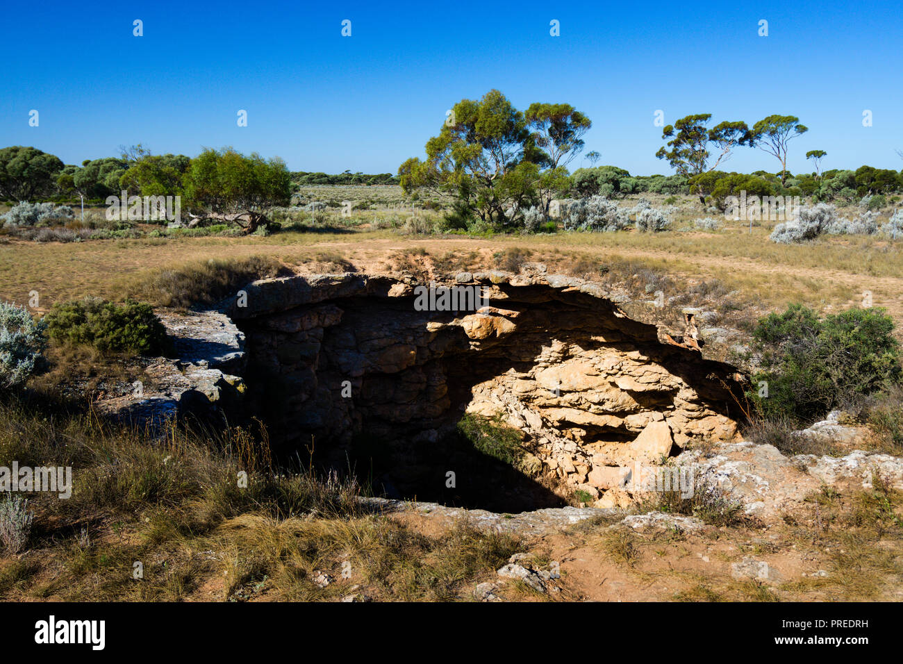 The opening to Murra-el-Elevyn Cave on the Nullabor Plain near Cocklebiddy Western Autralia Stock Photo