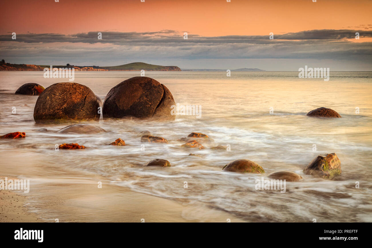 The famous Moeraki Boulders, an icon of New Zealand, in Otago, at sunrise. Stock Photo
