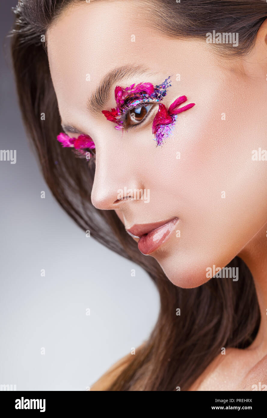 Beautiful young woman with fashion makeup against a gray background Stock Photo
