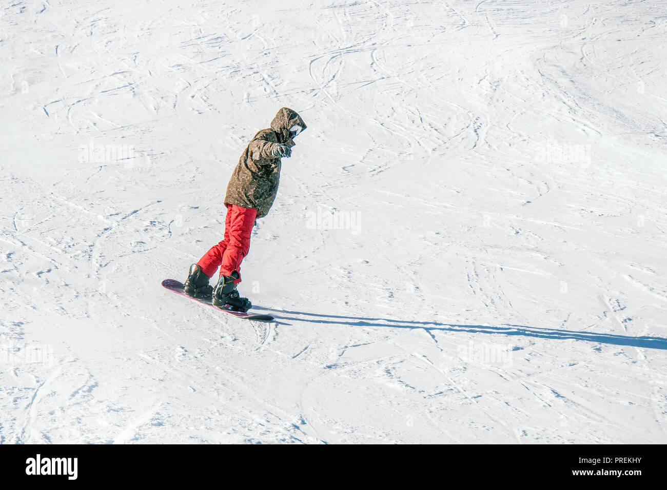 Snowboarding in red pants in mountains on the background of white snow  Stock Photo - Alamy