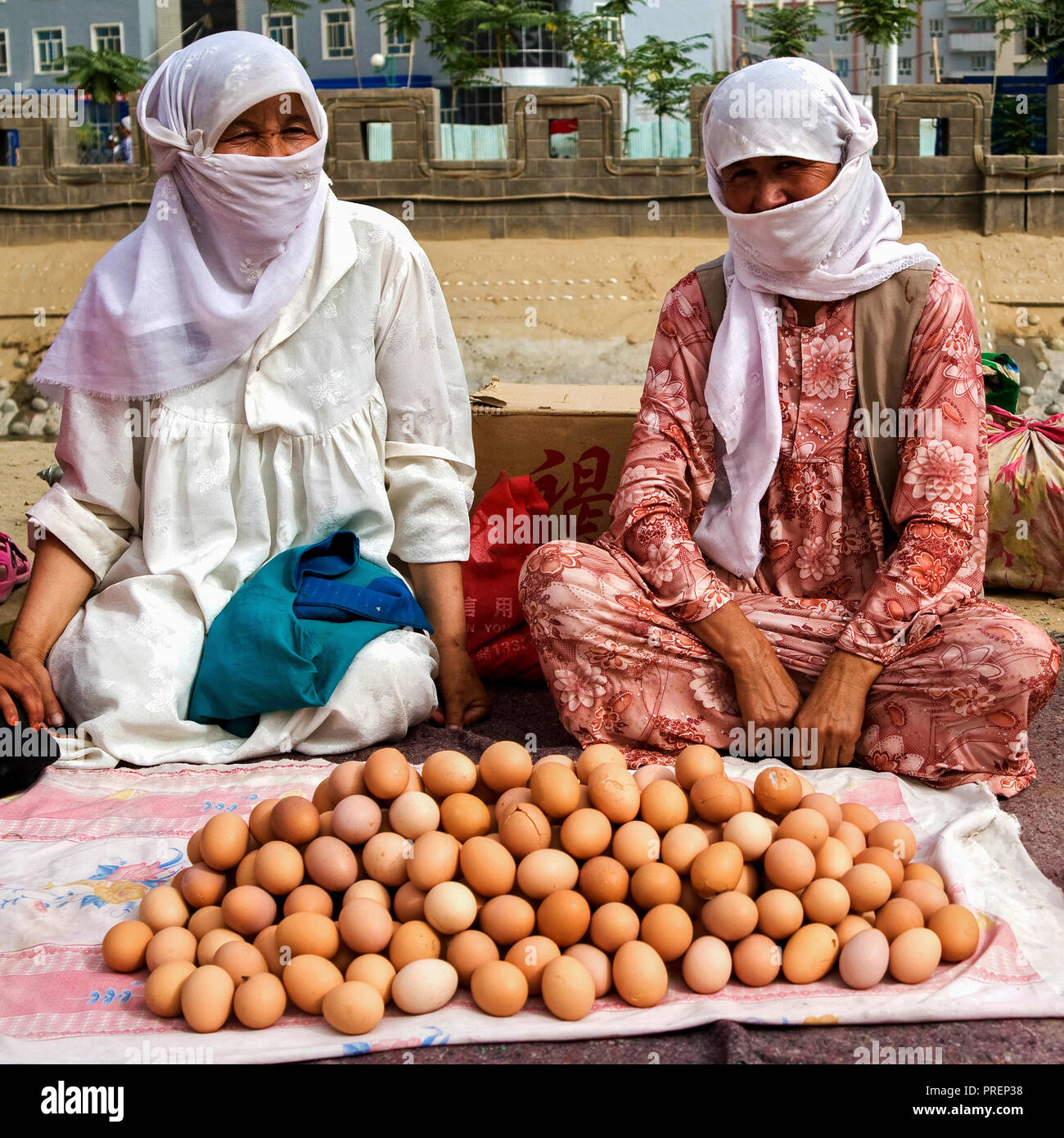 Two women selling eggs at a bazaar along the streets in Yutian town