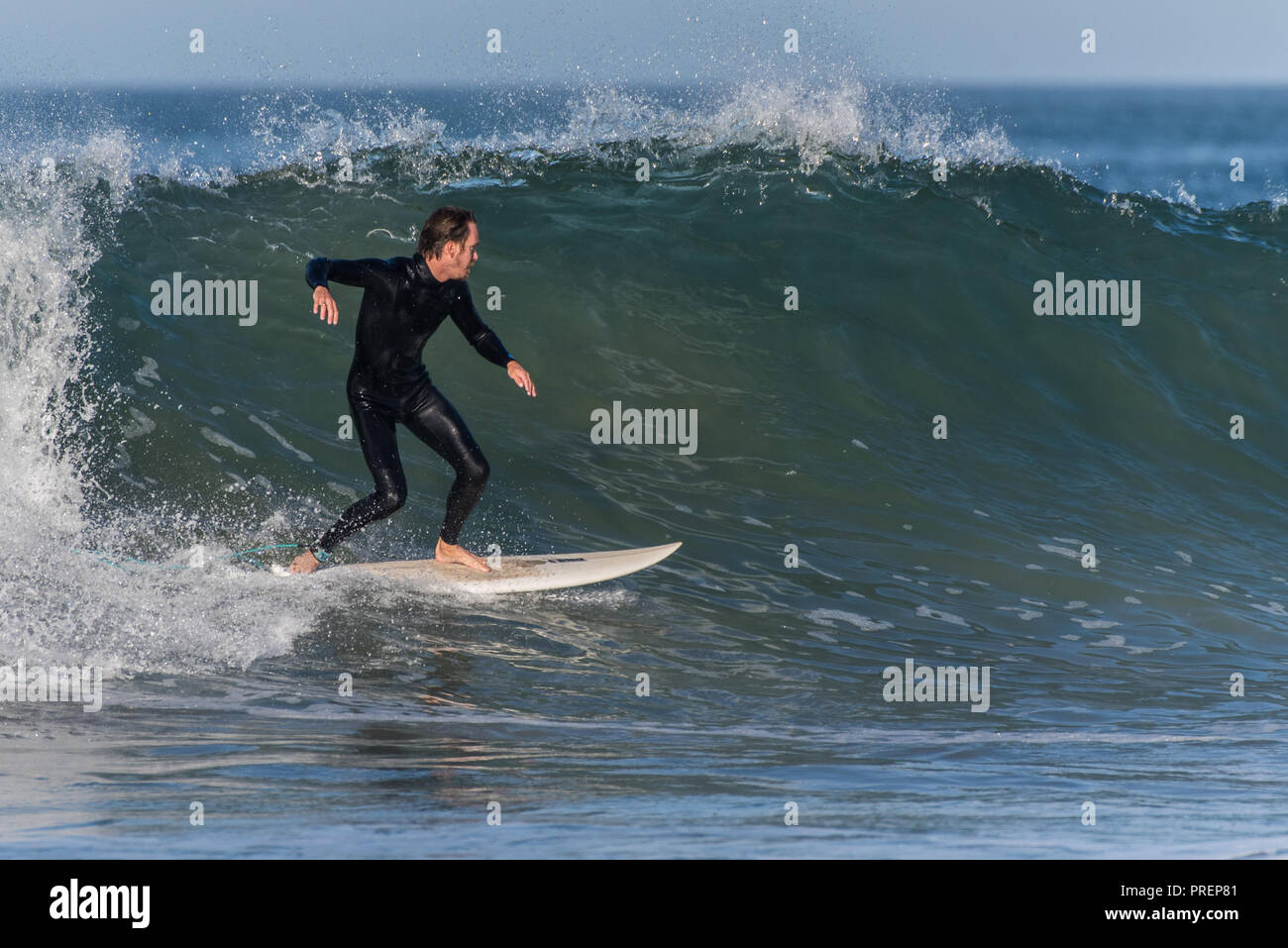 Surfer in black wetsuit finds smooth and glassy section of wave at Surfer's Knoll, Ventura, California on October 1, 2018. Stock Photo