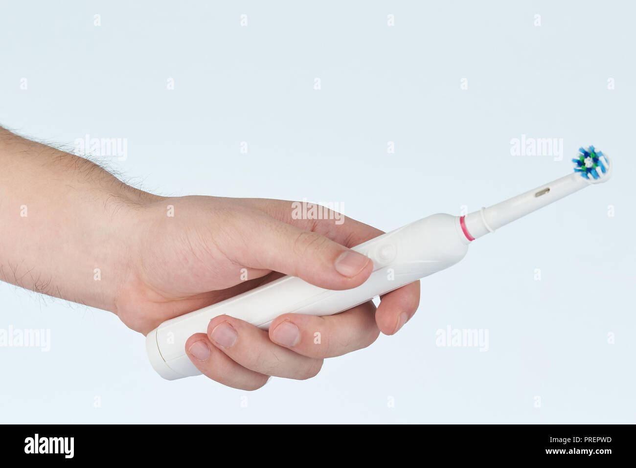 Hand hold electric toothbrush isolated on white studio background Stock Photo